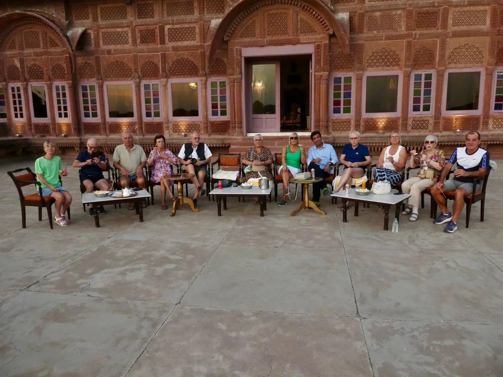 A travel group relaxing in the courtyard of a carved sandstone haveli